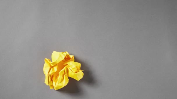 egy összegyűrt sárga papírgolyó fut be a keretbe, és kiegyenesíti, megáll morion animáció - Felvétel, videó