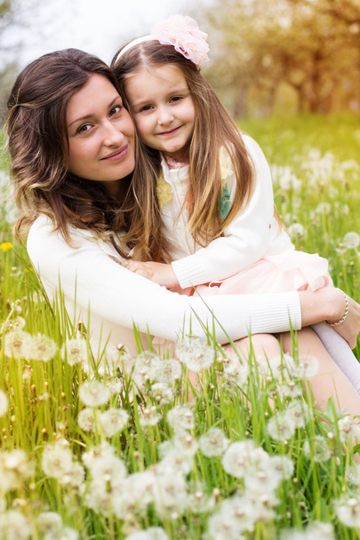 Mother and daughter in field with dandelions - Фото, изображение