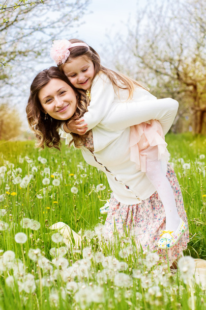 Mother and daughter in field with dandelions - Фото, зображення