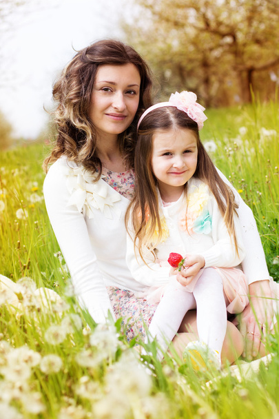 Mother and daughter in field with dandelions - Photo, image