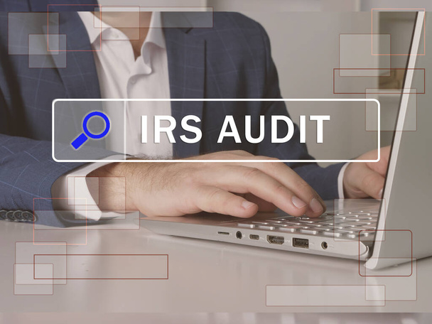  IRS AUDIT Internal Revenue Service text in search bar. Loan officer looking for something at laptop. IRS AUDIT Internal Revenue Service concept. - Photo, Image