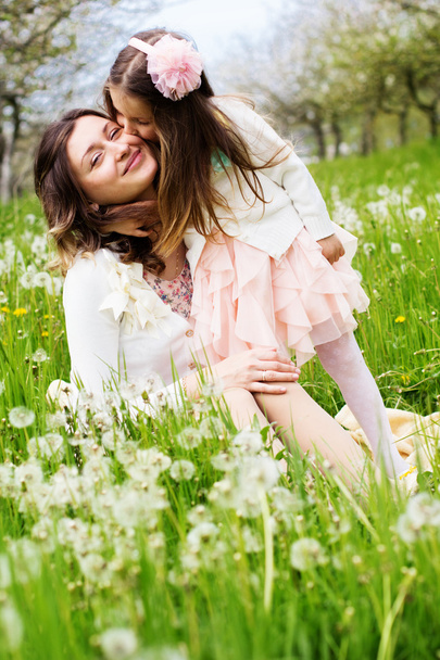 Mother and daughter in field with dandelions - 写真・画像