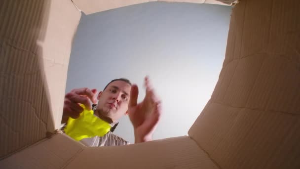 Видео, как человек бросает мятую желтую бумагу, вид снизу - Кадры, видео