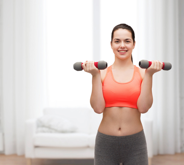 Young sporty woman with light dumbbells - Foto, immagini