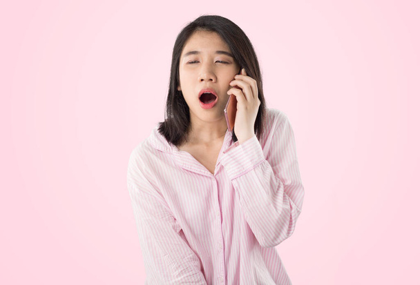 giovane donna asiatica in possesso di cellulare sentire assonnato - Foto, immagini