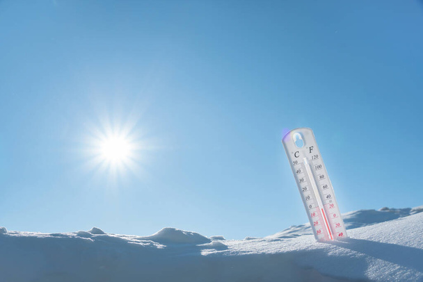 Teploměr leží na sněhu v zimě a vykazuje negativní teplotu.Meteorologické podmínky v drsném podnebí v zimě s nízkým vzduchem a okolními teplotami.Zmrazení v zimě.Slunečná zima - Fotografie, Obrázek