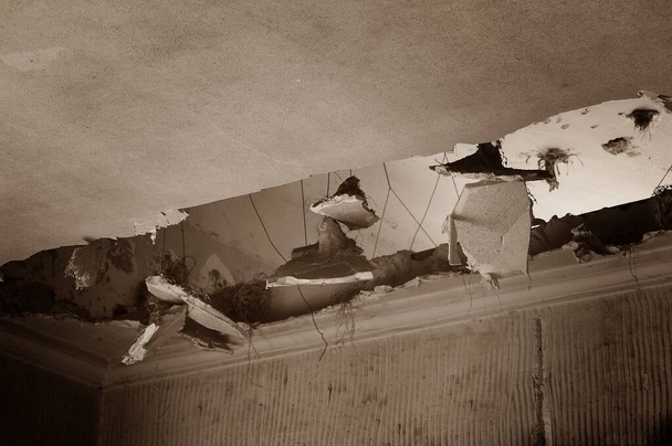 Trou dans le plafond d'une pièce. Les décombres d'un bâtiment abandonné et délabré. - Photo, image