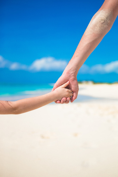 Zamknij z ojcem i córeczka siebie trzymając ręce na plaży - Zdjęcie, obraz