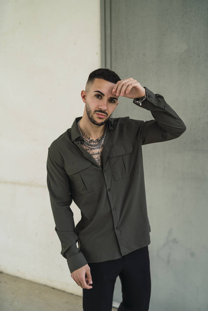 A Caucasian young man in casual style with chain and tattoos - Foto, Bild