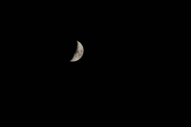 Το πρώτο τέταρτο του φεγγαριού στον ουρανό. Το φεγγάρι που φτάνει είναι ο χρόνος από το νέο φεγγάρι στην πανσέληνο. - Φωτογραφία, εικόνα