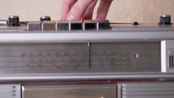 La mano femenina endereza la antena del receptor vintage gris con el cassette dentro - Imágenes, Vídeo