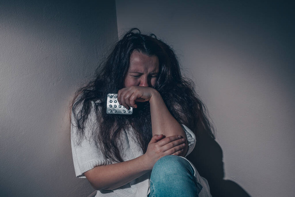 Mujer joven que sufre de una depresión severa o trastorno de ansiedad con píldoras antidepresivos, distracciones y concepto de angustia - Foto, imagen