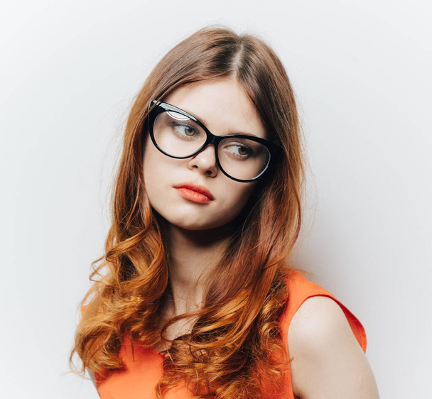 hübsche Frau in orangefarbenem Kleid und Brille Make-up Porträt - Foto, Bild