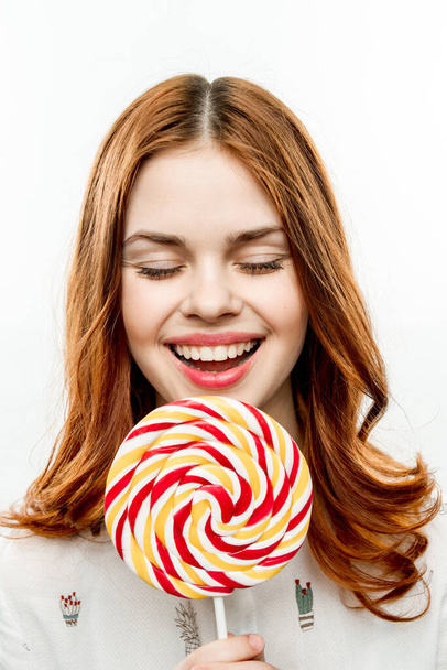 emotional woman with round multicolored lollipop near face enjoyment joy - Photo, image