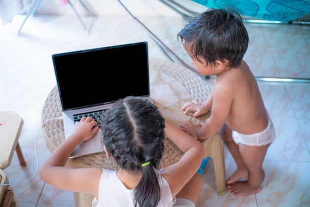 Słodkie i szczęśliwe małe dziewczynki dzieci za pomocą laptopa studiuje internet online z małym chłopcem - Zdjęcie, obraz