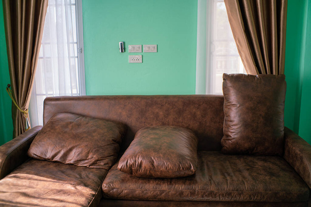 Brązowy olej skórzana sofa z poduszkami w pokoju nowego domu zielony pokój - Zdjęcie, obraz