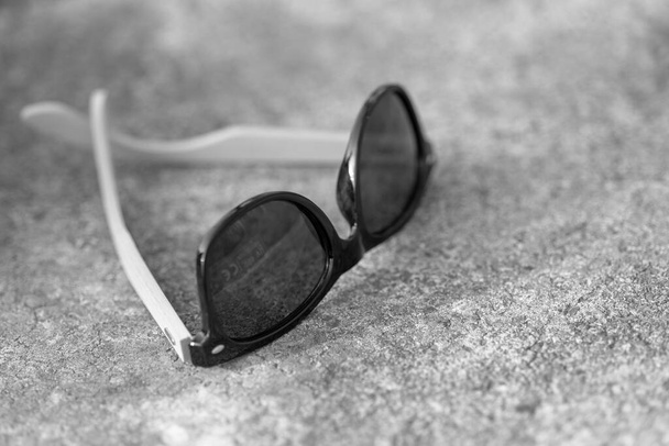 Classic sunglasses model with black lenses shoot in creative outdoor place closeup. Selective focus - Photo, Image