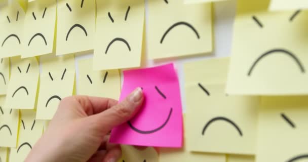 Zakelijke vrouw handen stok notitie glimlachend symbool op trieste achtergrond. Het concept van een succesvolle oplossing van het probleem. Positief idee of nieuws. - Video