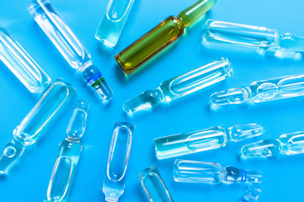 A lot of ampoules for injections on a blue background. Medical background. - Photo, Image