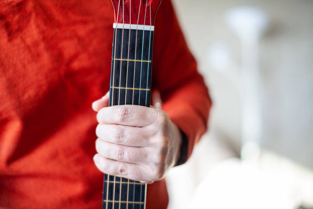 Detailní záběr kytaristy nebo člověka, který se učí hrát na akustickou kytaru. Domácí výuka hrát na hudební nástroj - Fotografie, Obrázek
