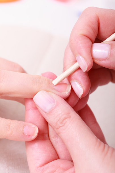 Beautician cleaning cuticles hands with cosmetic stick. Beauty spa salon - Photo, image
