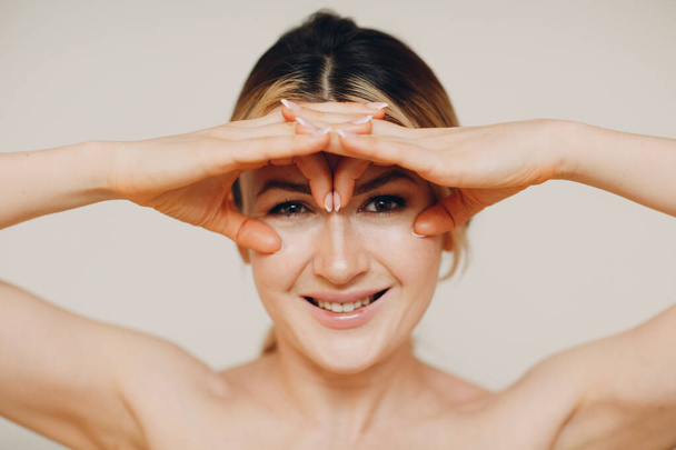 Jovem mulher adulta fazendo ginástica facial auto-massagem e exercícios rejuvenescedores construção facial para levantamento de pele e músculos - Foto, Imagem