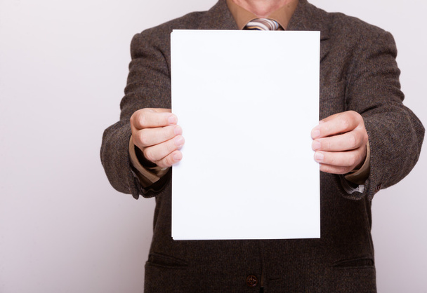 Businessman holding blank sheet of paper. Business concept. - 写真・画像