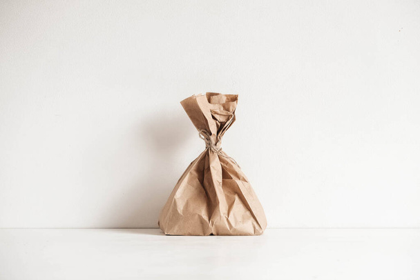 Full disposable bag of brown kraft paper on a white background. Copy, empty space for text. - Photo, Image