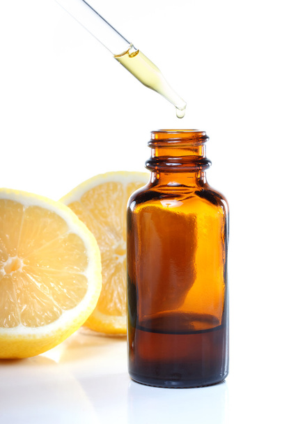kruidengeneeskunde druppelaar fles met citroenen - Foto, afbeelding