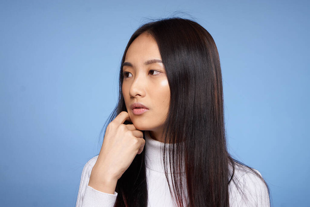 brunetka asijské dotýkání tvář s rukou make-up model bílý svetr - Fotografie, Obrázek