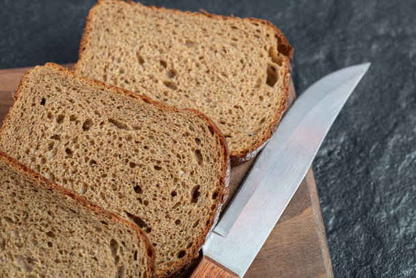 Kromki świeżego bochenka chleba na drewnianej desce - Zdjęcie, obraz