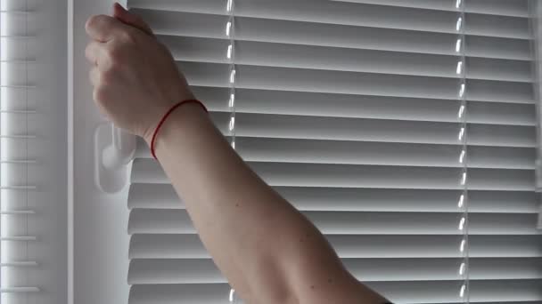 Egy nő nyitott fehér műanyag ablak a fogantyú és csukott redőny. - Felvétel, videó