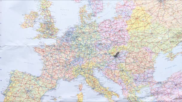 Ferma il video di una piccola auto monopolio d'argento che gira su una mappa dell'Europa. Breve clip per illustrare il viaggio in Europa - Filmati, video