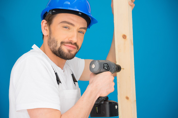Builder using a drill looking at the camera - Zdjęcie, obraz