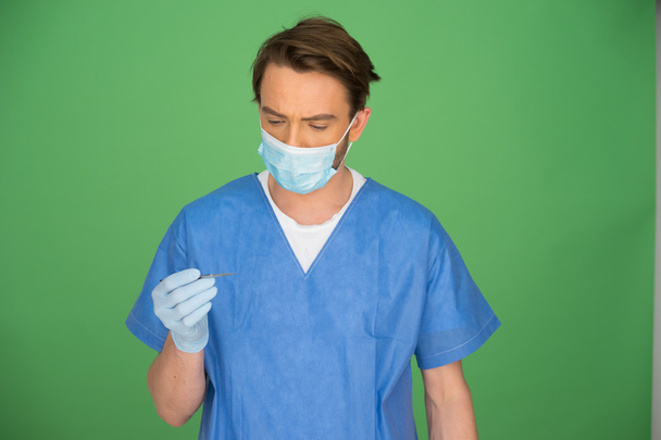 Homme médecin ou infirmière regardant sa main gantée
 - Photo, image
