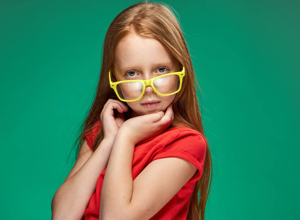 menina emocional com cabelo vermelho vestindo óculos amarelos escola isolado fundo - Foto, Imagem