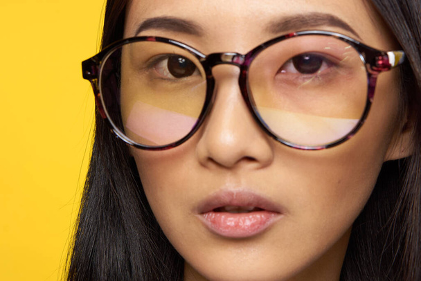 élégant femme lunettes visage gros plan studio fond jaune - Photo, image