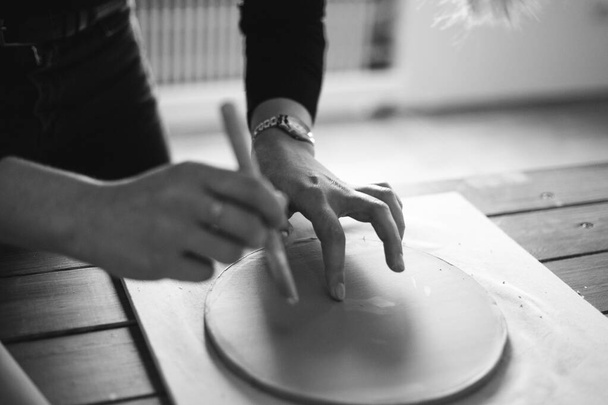 Mãos femininas rolar o barro com um rolo na mesa na cerâmica - Foto, Imagem