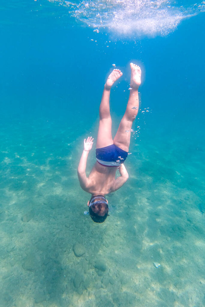 Petit enfant plongeant en apnée sur une eau claire - Photo, image