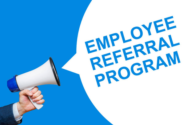 A hand is holding a megaphone with speech bubble Employee Referral Program. Announcement and advertising. - Photo, Image