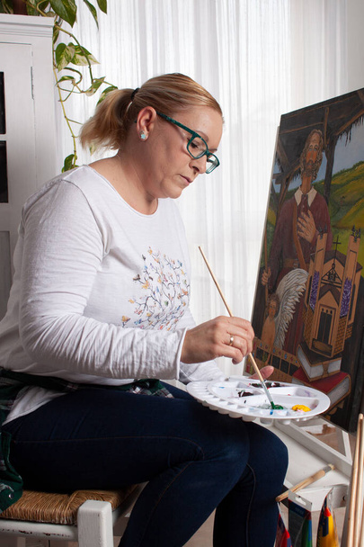 widok młodej kobiety w jej salonie malowanie obraz korzystających z jej hobby i zrelaksowany - Zdjęcie, obraz