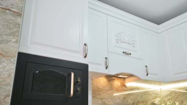 Szekrény billenő kamera mozgás a modern klasszikus fehér konyha belső - Felvétel, videó