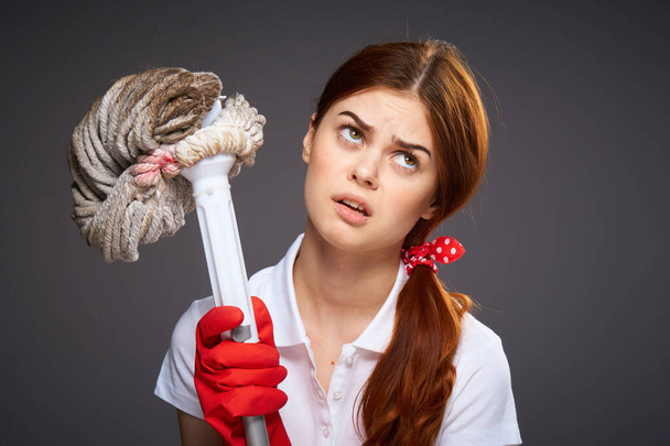 cleaning lady with disgruntled expression mop in hand cleaning rooms - Фото, изображение