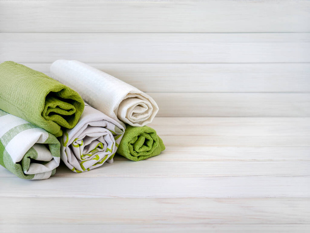 Uma pilha de toalhas bem dobradas em um fundo de madeira. Produção de fibras têxteis naturais. Produto orgânico. Materiais naturais. - Foto, Imagem