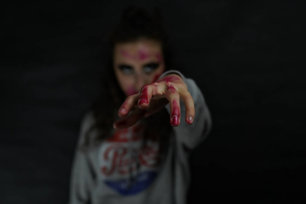 Dziewczyna z zakrwawioną ręką. Makijaż na Halloween - Zdjęcie, obraz
