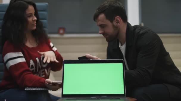 Tecla de croma en la pantalla del ordenador portátil. Dos personas están sentadas en un portátil. - Imágenes, Vídeo