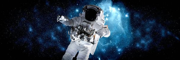 Astronaut kosmonaut dělat vesmírnou procházku, zatímco pracuje pro vesmírnou stanici - Fotografie, Obrázek