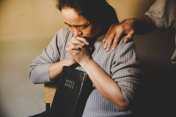 Paar liest Bibel und betet zu Hause zusammen. Zwei Menschen beten zusammen. enge Hände - Foto, Bild
