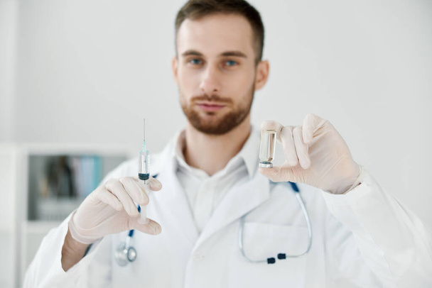 medico maschio in abito medico tiene una siringa nella sua mano vaccino sanitario laboratorio chimico liquido - Foto, immagini
