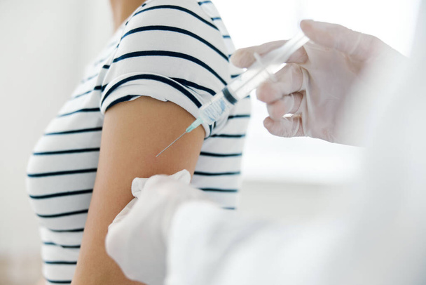 Injection of vaccine into shoulder in hospital close-up - Fotoğraf, Görsel